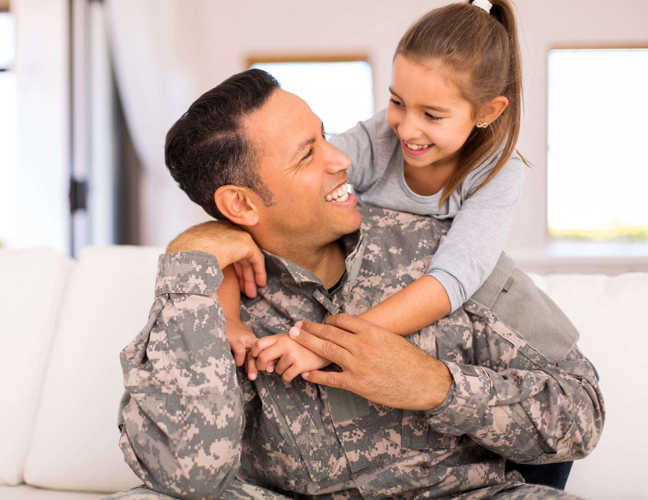 little girl hugging her military father